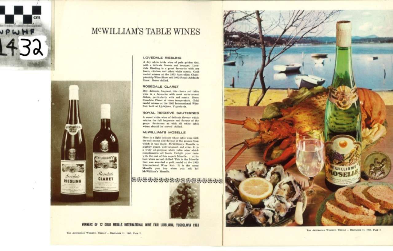 Wine ad spread with bottles, text, and a picnic scene of cheese, seafood, and a cat by the water