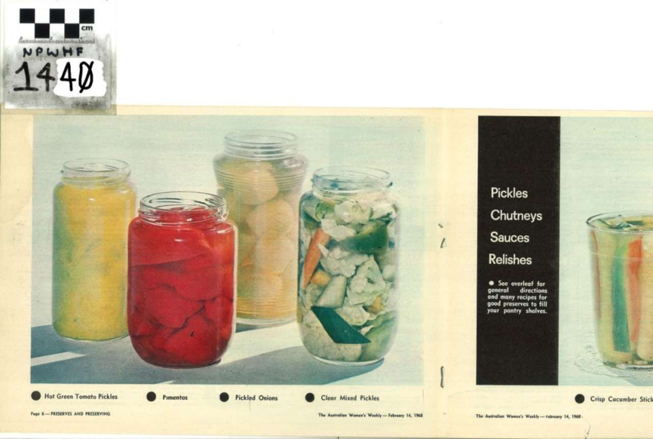 Jarred pickled vegetables and sauces with a black recipe label on a pale background.