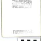 Blurry close-up of a book page with small printed text and a few black blocks at the bottom.