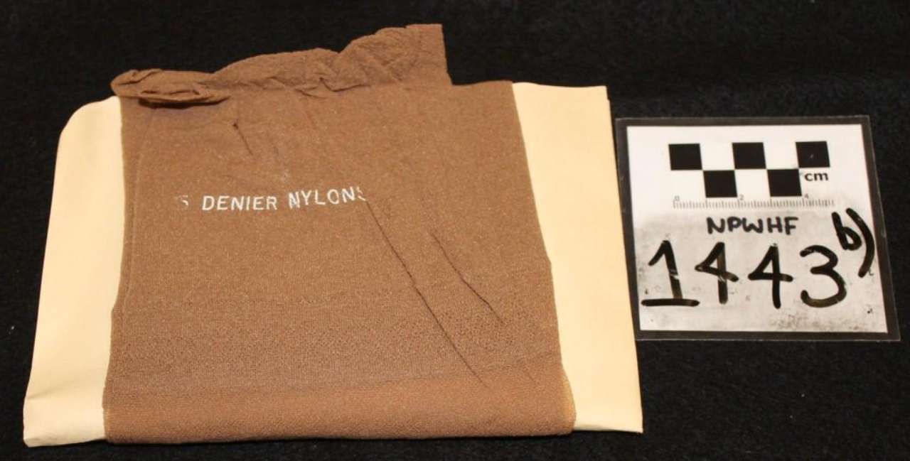Brown denim textile sample labeled “DENIM NYLON” beside evidence marker 1443 on black background