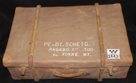 Brown strapped cardboard crate with a handle and white stencil text on the front, labeled “PE.DI.SCHEID. ANDORRA, N.Y. 100 V. FINKE, MT.”