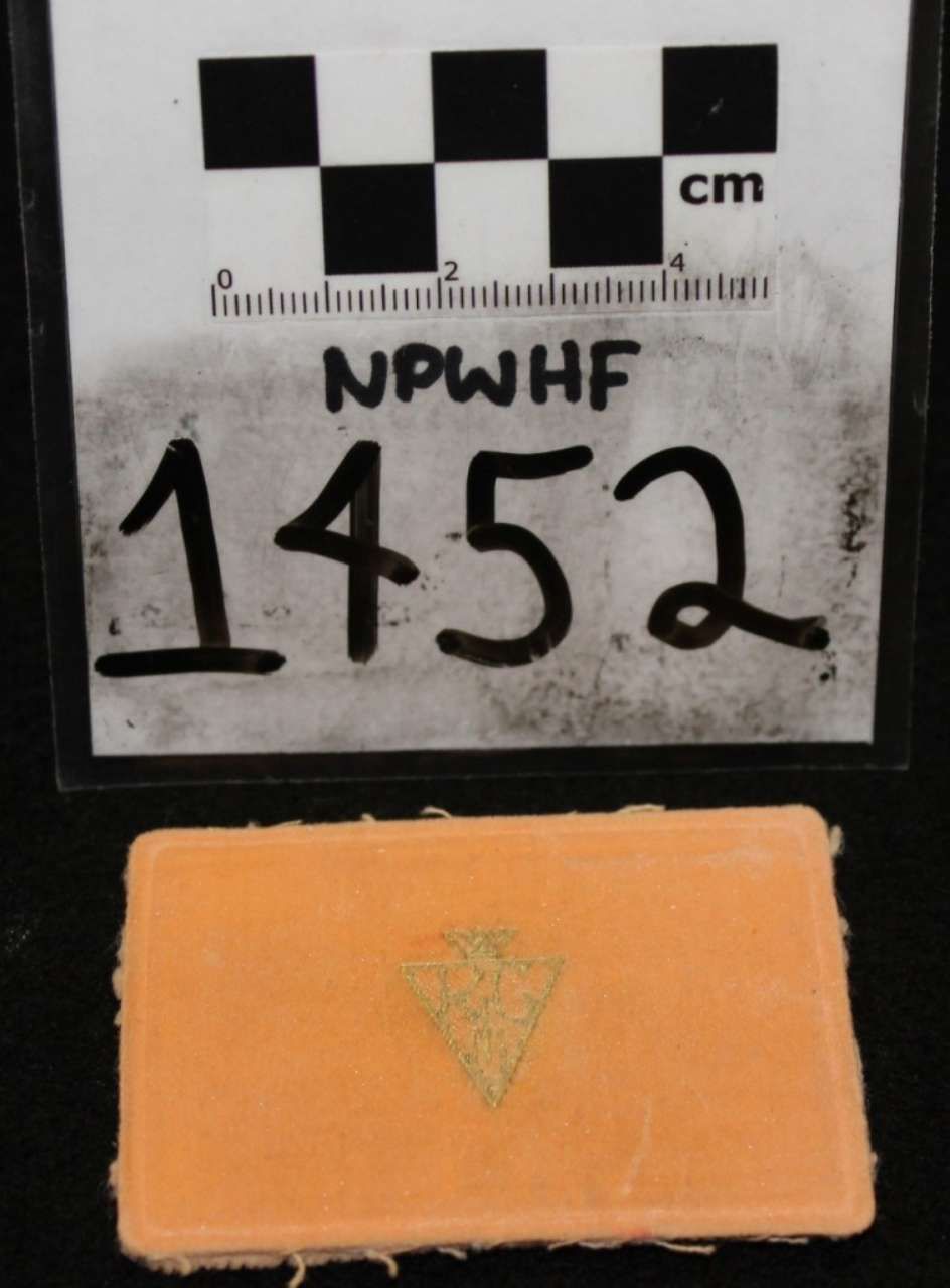 Orange tile fragment with faded triangular marking, labeled 1452 beneath a cm scale