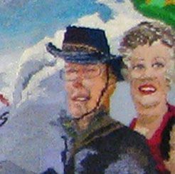 Two smiling painted figures in winter hats and coats, with a snowy mountain background