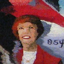 Smiling person in a red outfit and hat against a white and red background with the number 854 visible