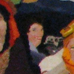 Blurry crowd scene with a person in a dark jacket and colorful clothing around them