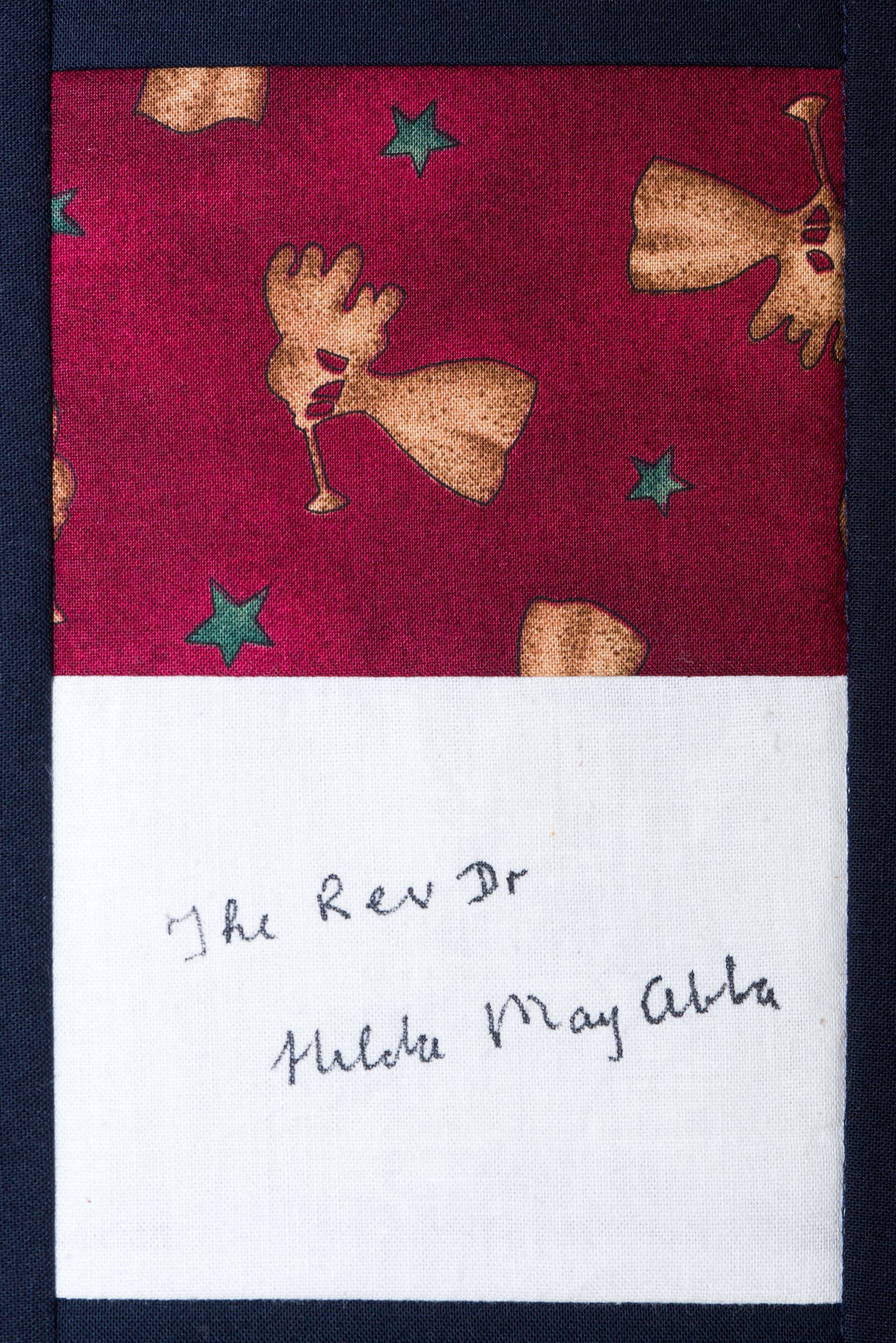 White note with handwritten text on red patterned fabric background