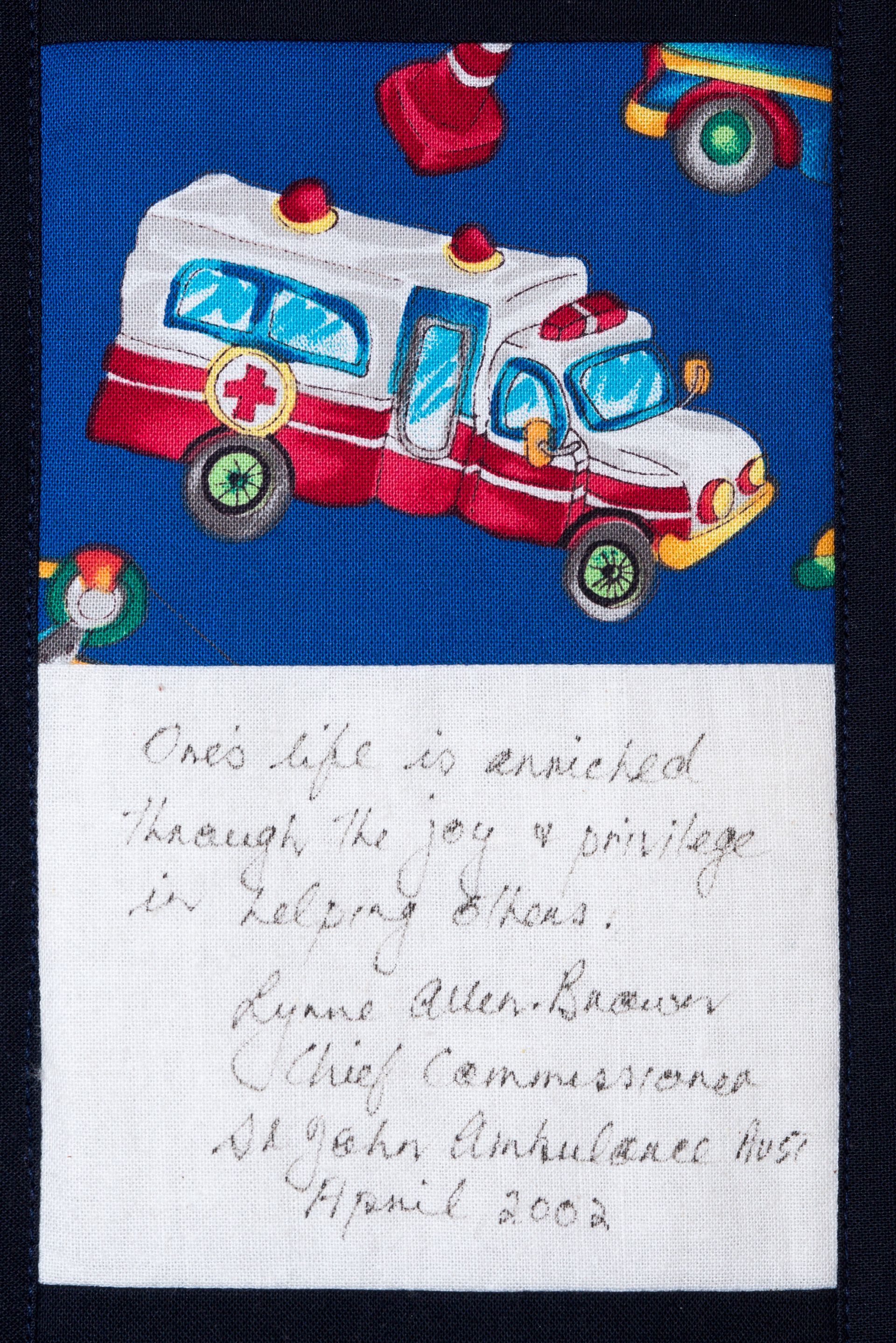Hand-painted red and white ambulance toy on blue background, with handwritten note below