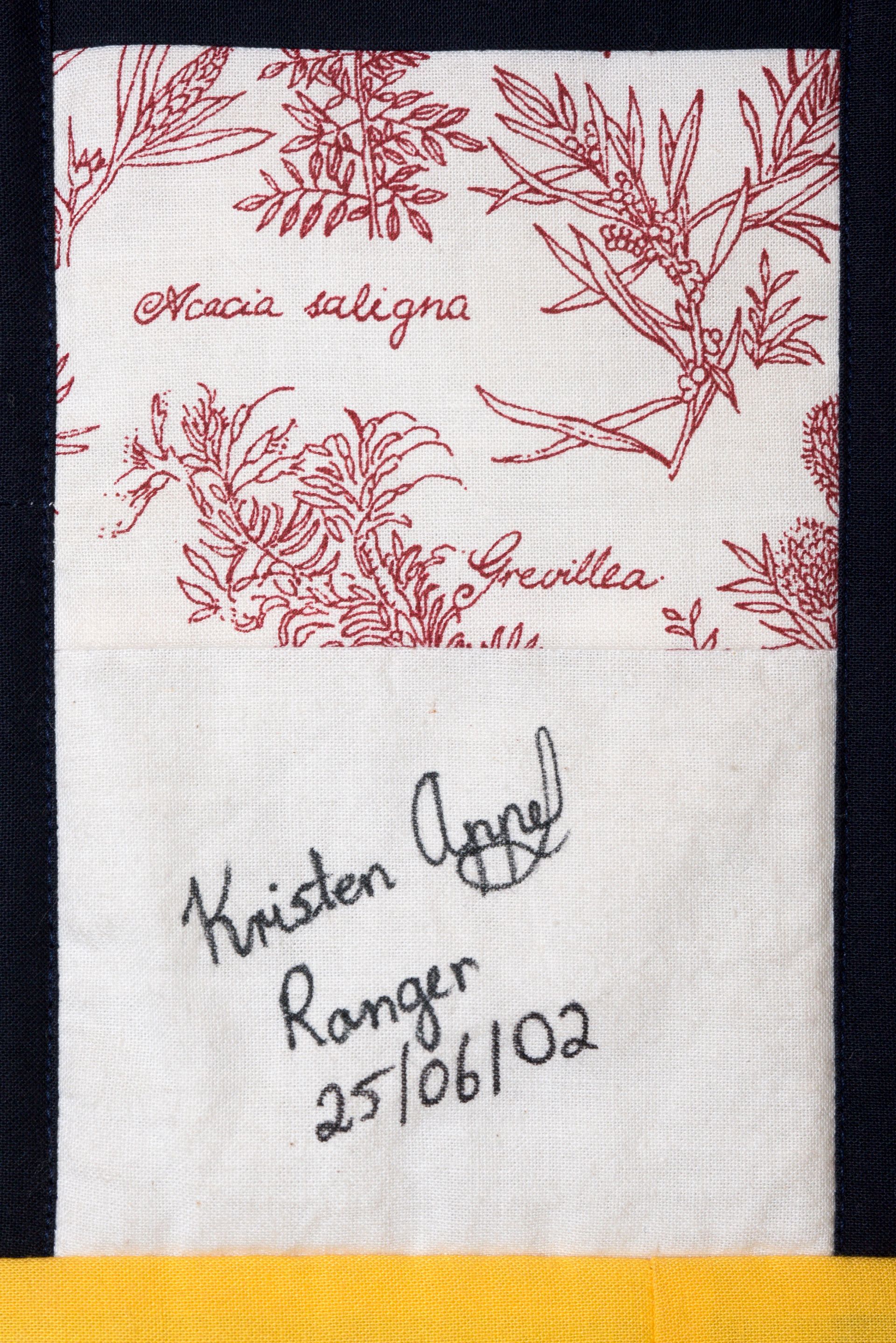 Floral red embroidery on white fabric with handwritten text: “Kristen Rangel 25/06/02”.