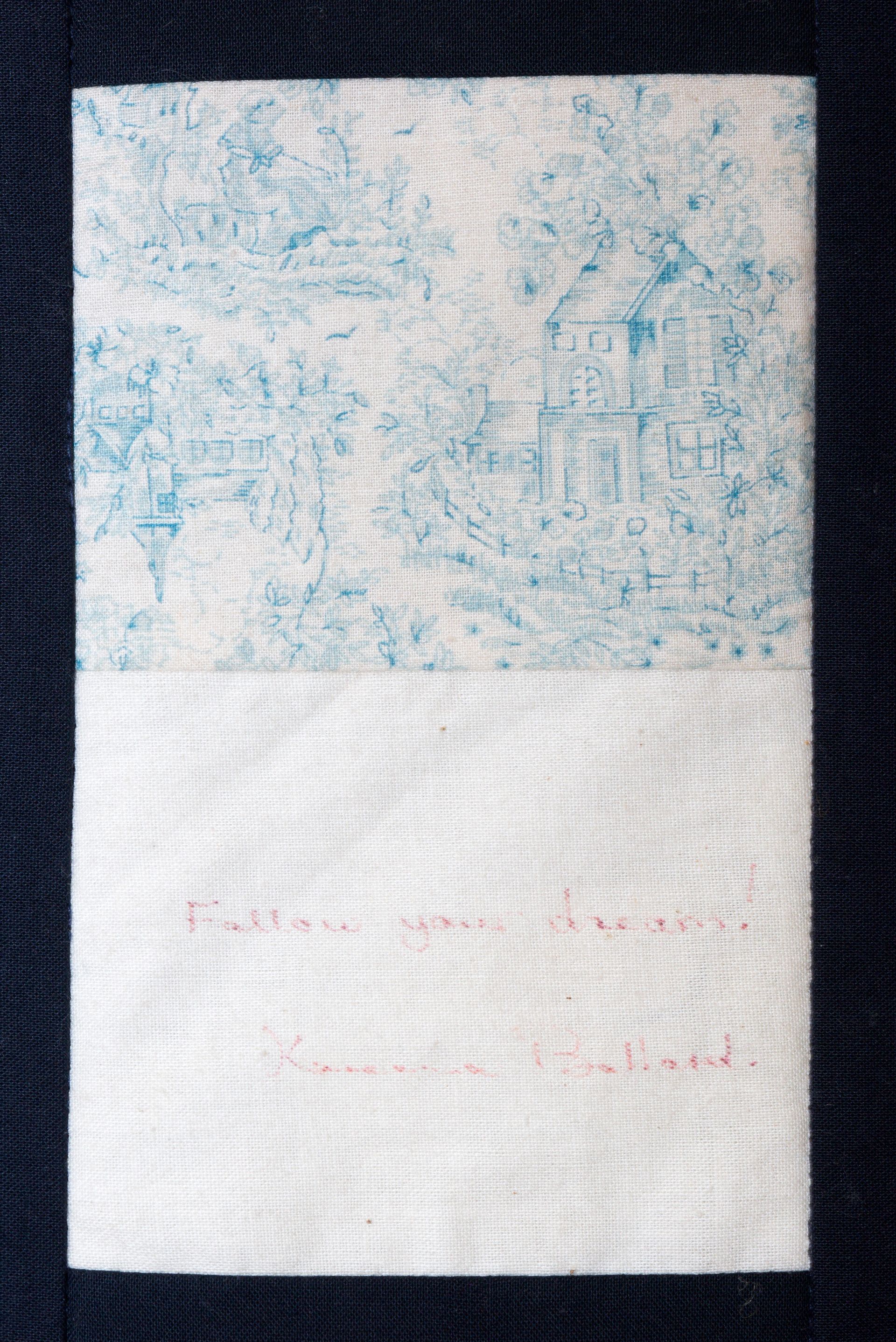 White note card with pale blue textured top and faint pink writing near the bottom.