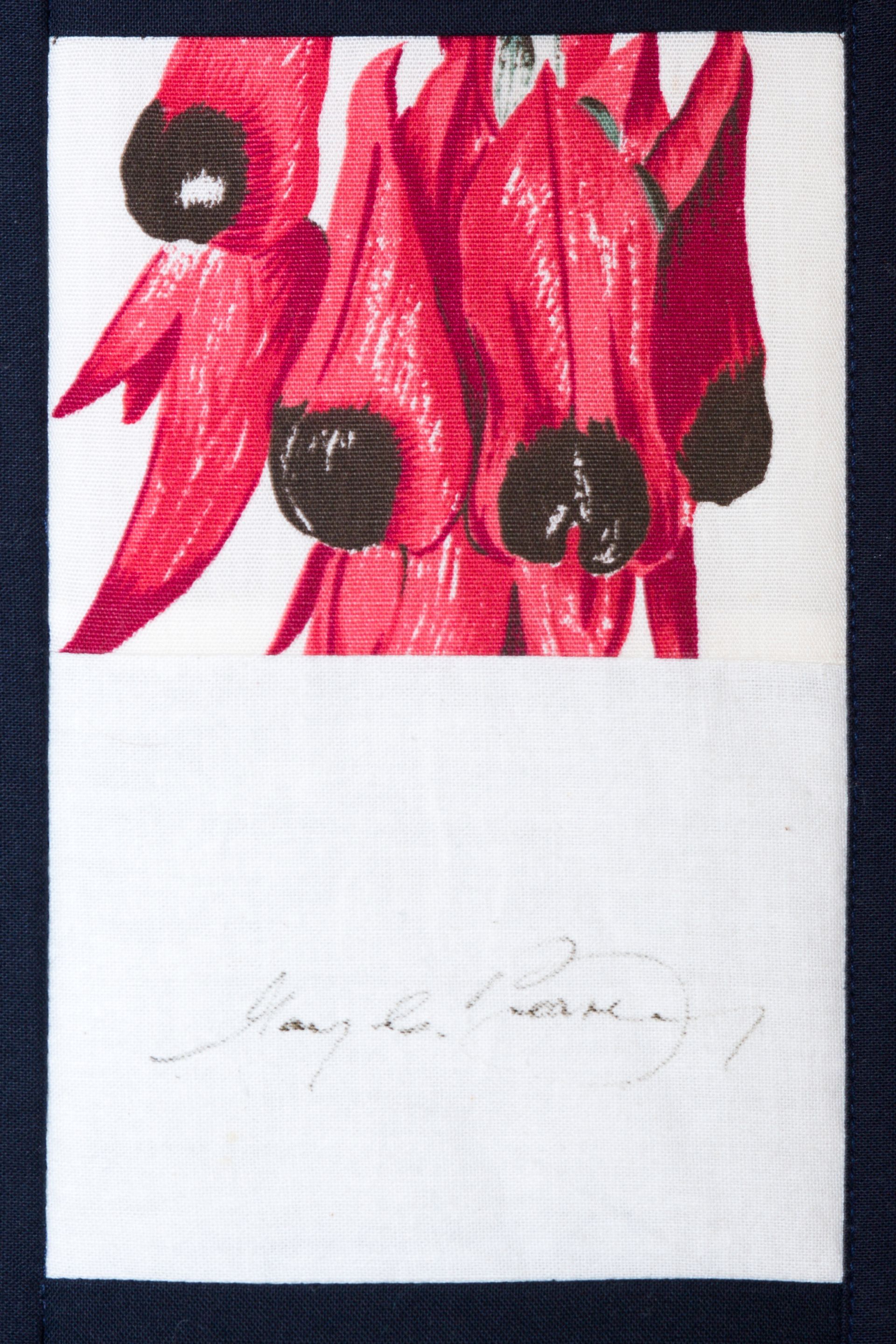 Abstract floral print in red and black on white fabric with faint cursive text below