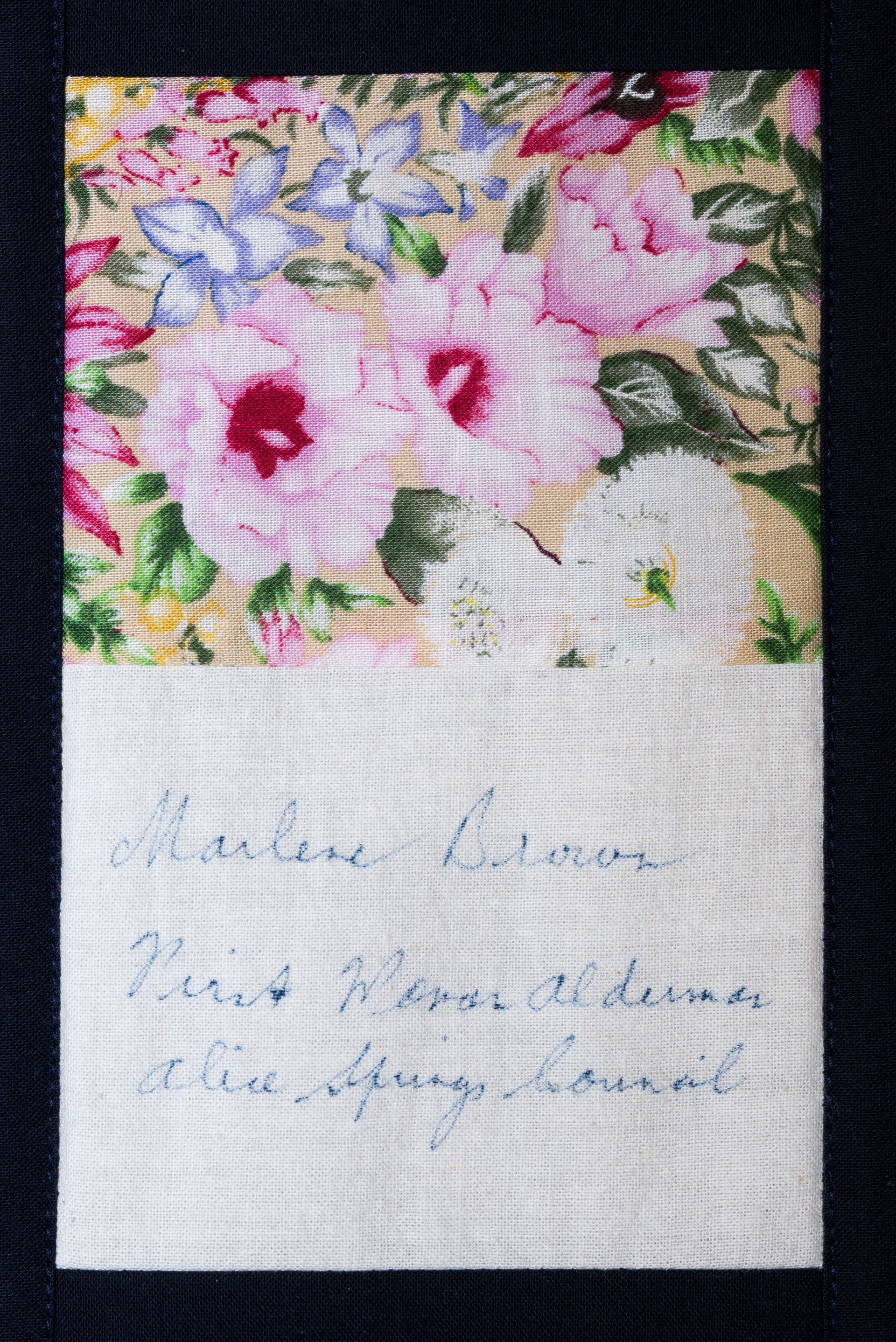 A small floral-printed note card with faint handwritten text on white paper