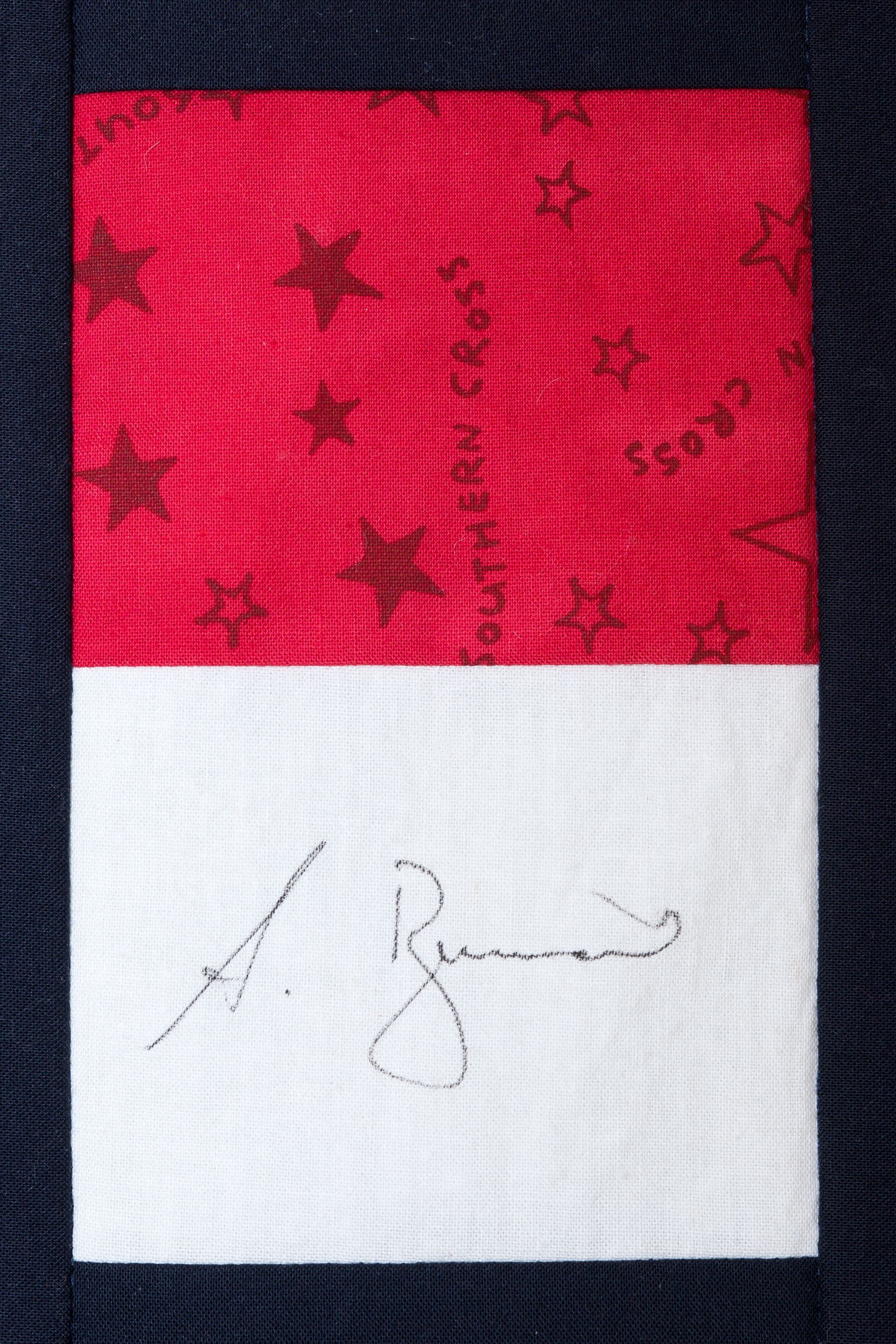 Red-and-white flag with a faint signature across the lower white section.