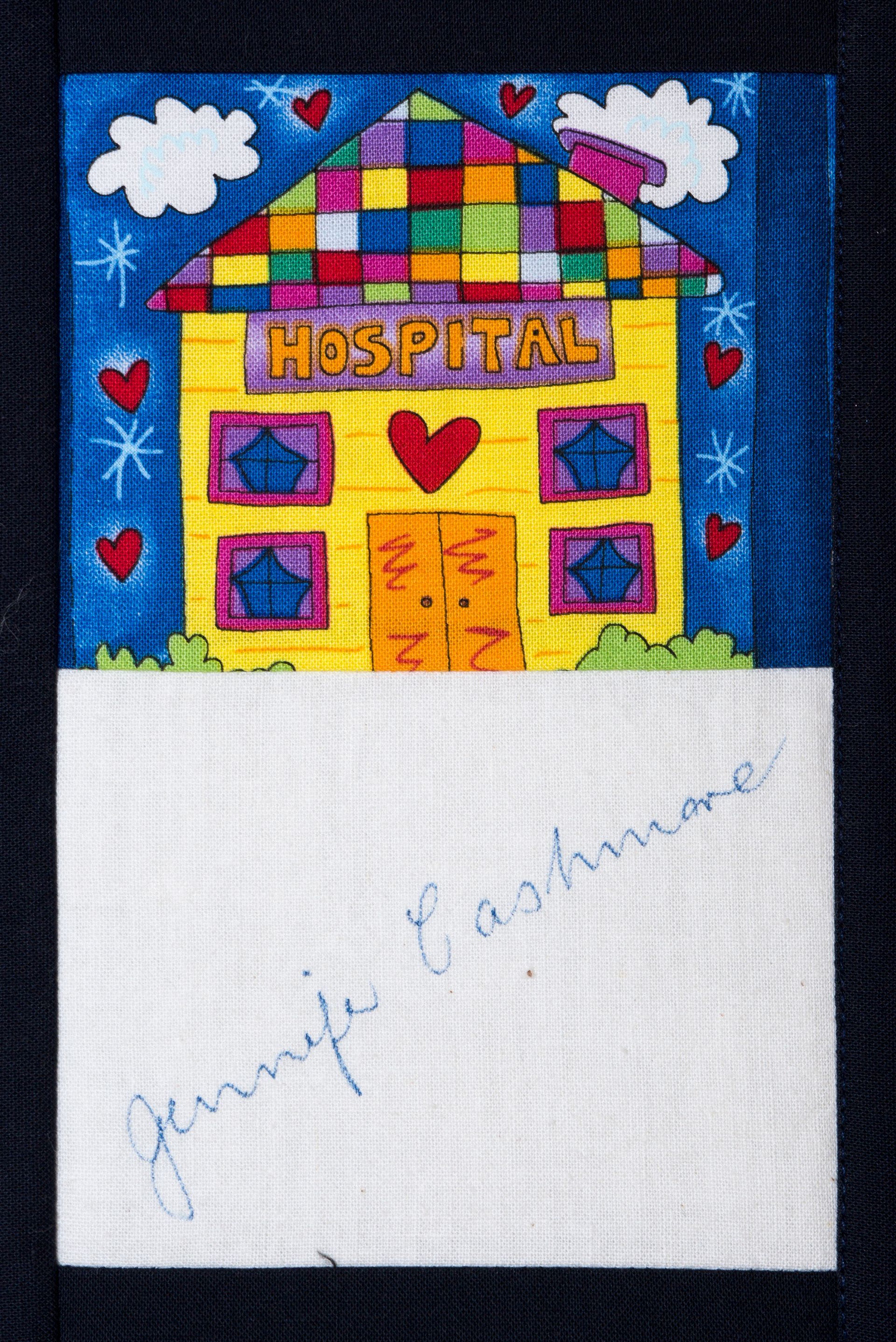 Colorful drawing of a house labeled “hospital” with hearts and clouds, on white paper with cursive writing below
