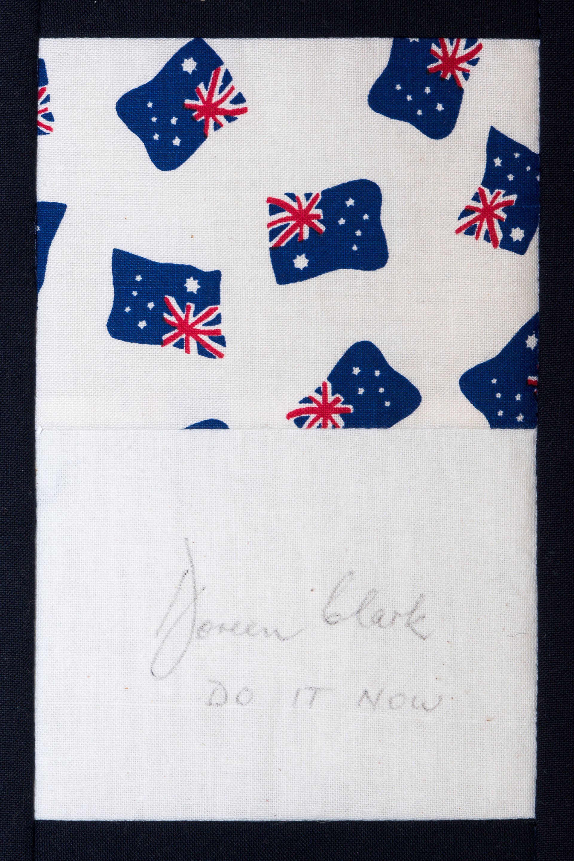 White fabric with blue-and-red Australian flag pattern above a faint handwritten note.