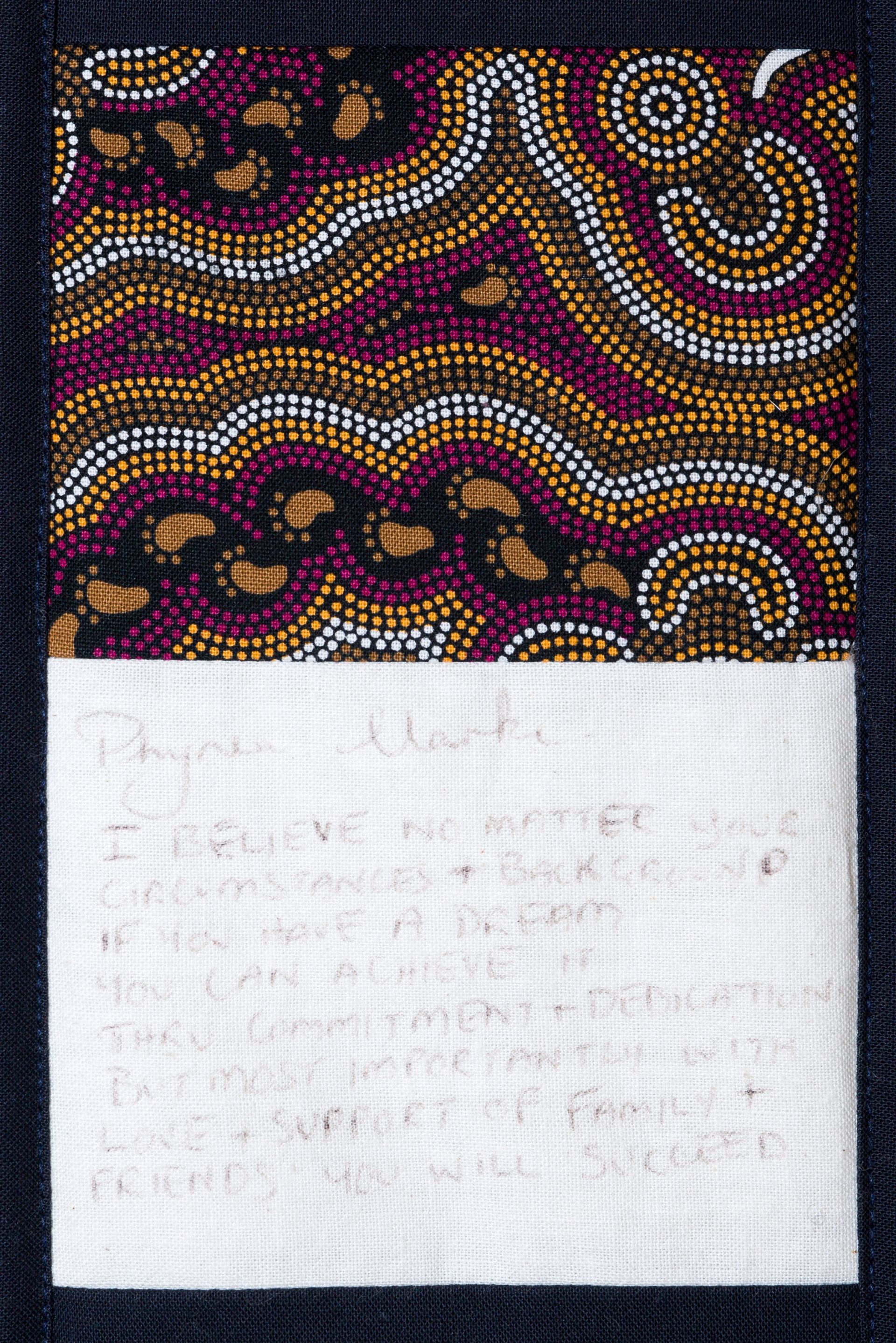Decorative abstract pattern above a white handwritten note on dark fabric