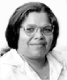 Portrait of a smiling person wearing glasses and a light-colored collared shirt