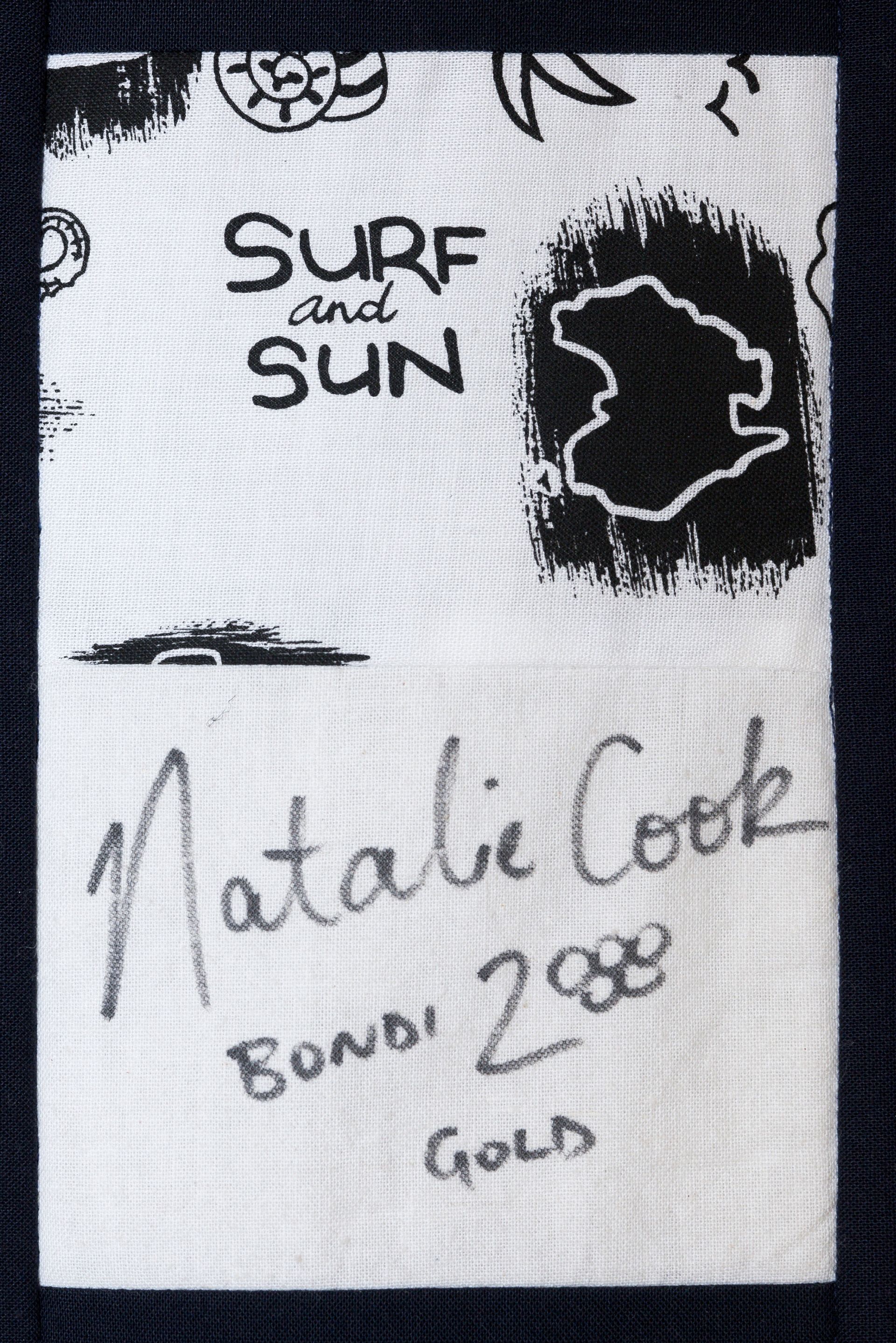 Surf and Sun surfboard label with “Natalie Cook,” “Bowl 288,” and “Gold” handwritten on it.