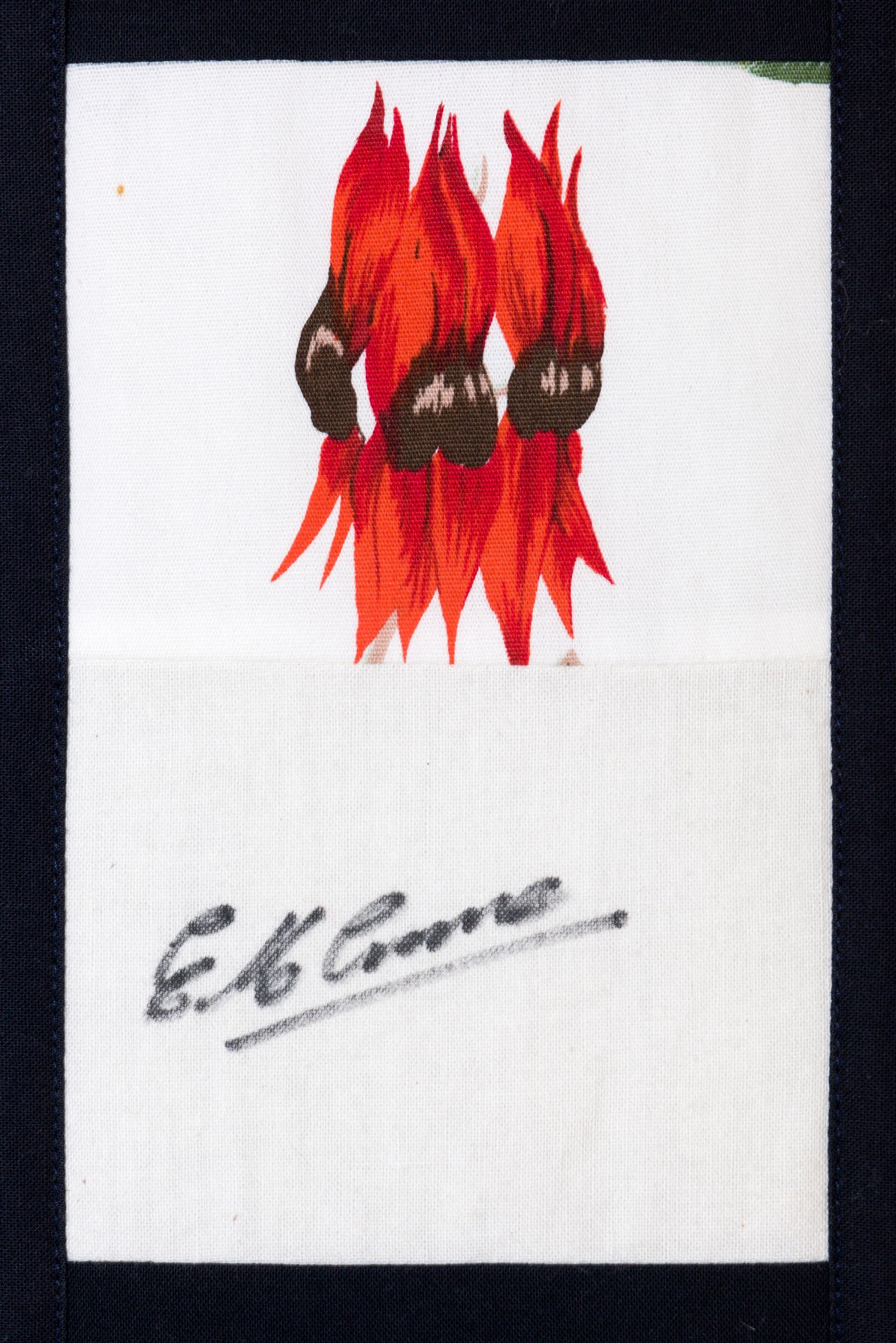White card with a red flame-like logo and a black signature below