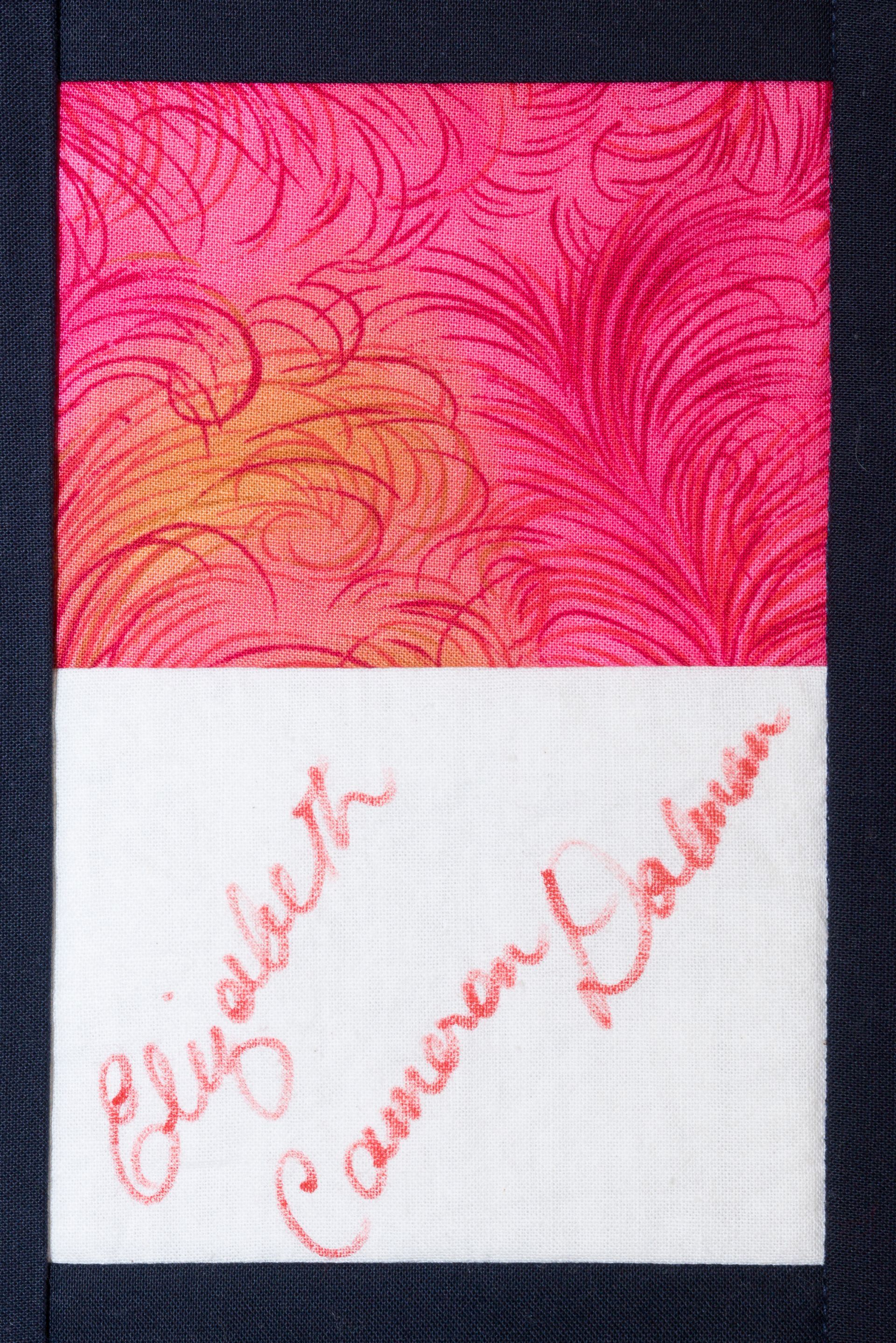 Pink patterned card with red cursive signatures on a white lower half
