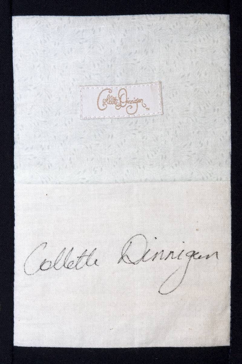 White paper with a small logo at top and handwritten signature below.