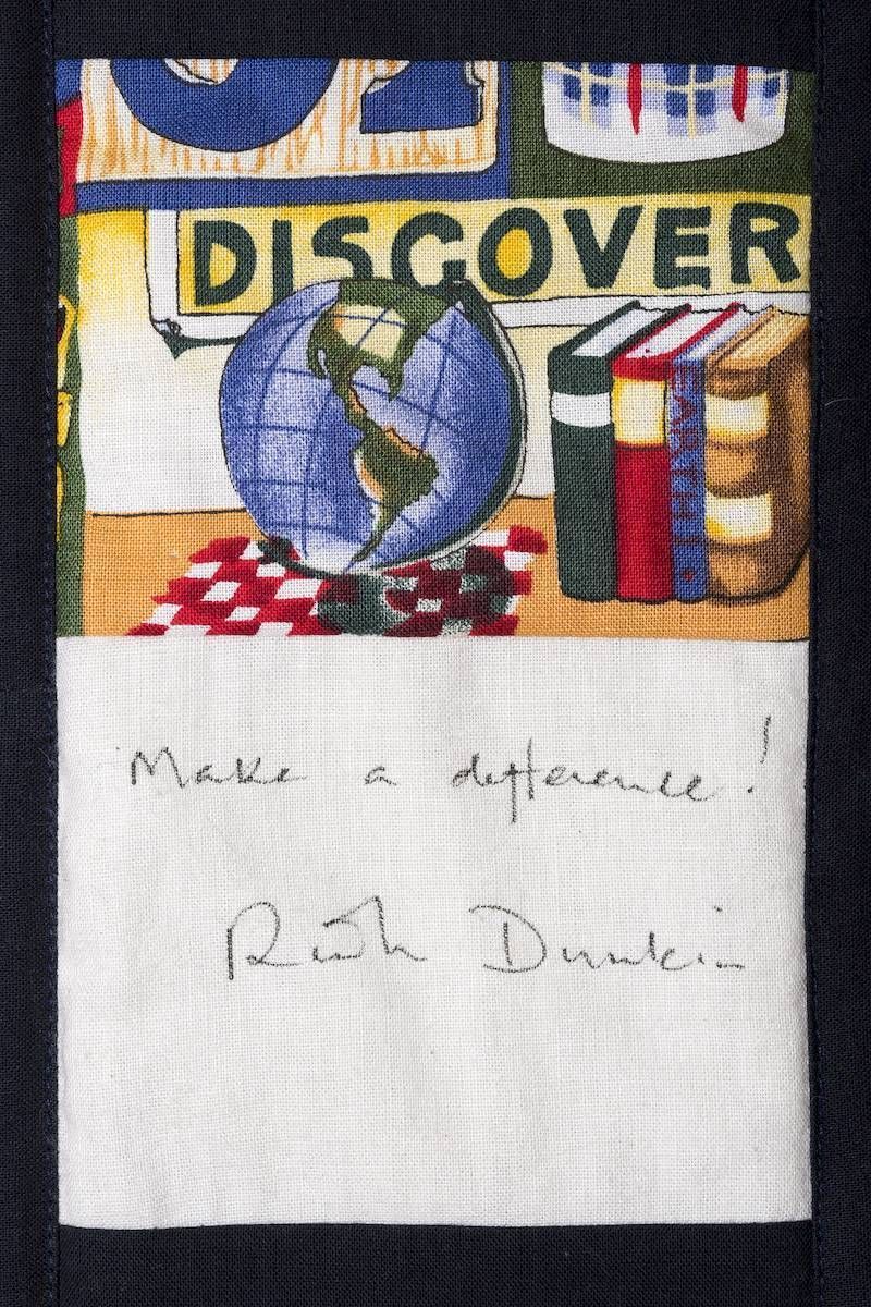 Handwritten note beneath a colorful “DISCOVER” patch with globe and books, saying “Make a difference! Ruth Drew.”