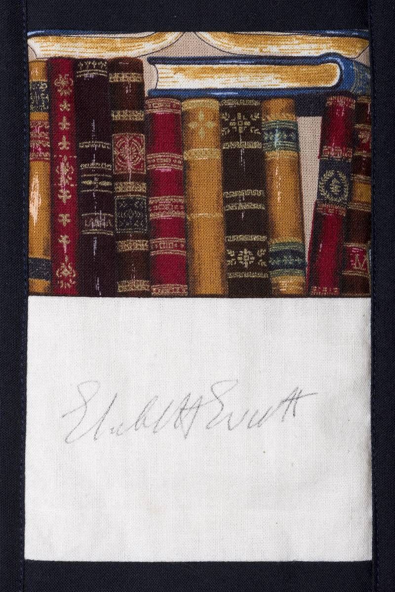 Stack of vintage books above a blank white label with faint handwriting