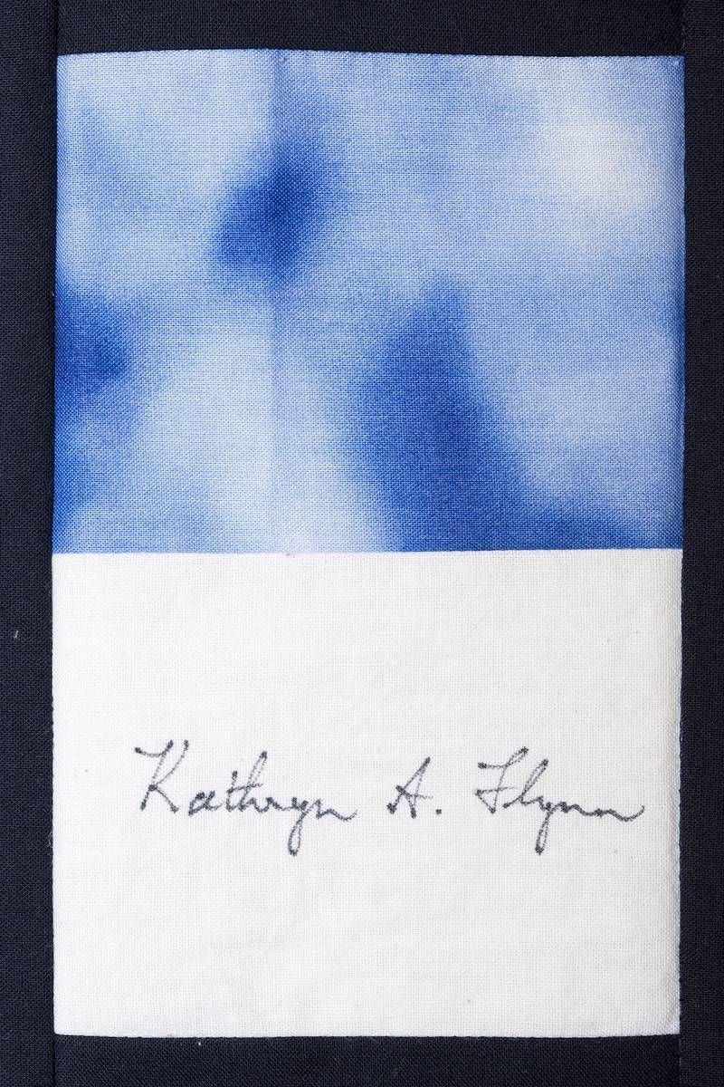 Blue-and-white abstract image with a handwritten signature at the bottom