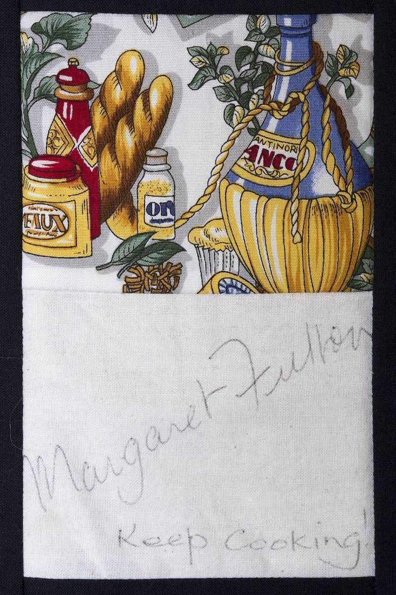Collection of mustard, ketchup, pickles, and a vinegar jug with a faint handwritten note below