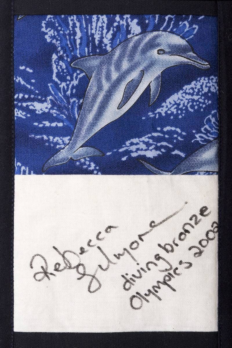 Blue dolphin artwork above a handwritten note on white paper with a signature and date