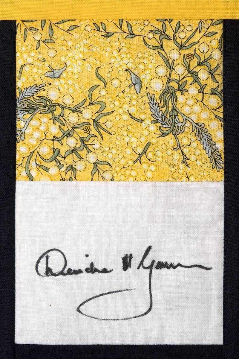 Abstract yellow marbled panel above a white strip with a black handwritten signature.