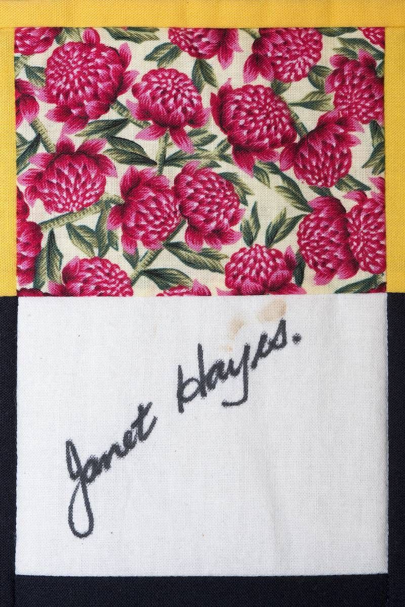 Floral fabric swatch above a white note card with handwritten signature “Janet Hayes.”