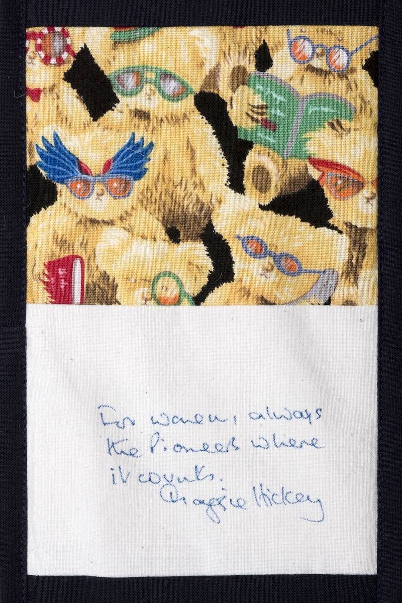 Patterned butterfly fabric above a white note with faint blue handwritten text