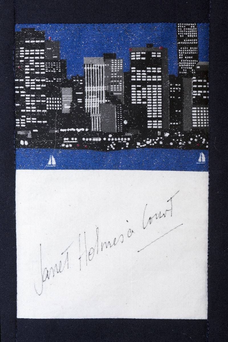Night city skyline above a white note with faint handwritten text on a dark background