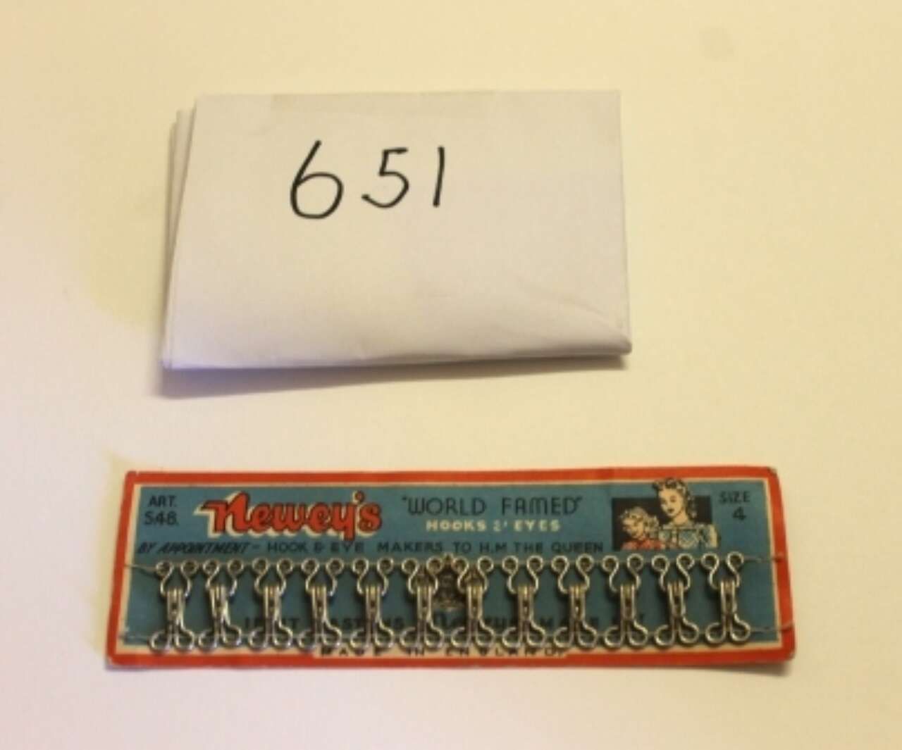 Folded paper labeled “651” above a blue-and-orange boxed set of small metal tools