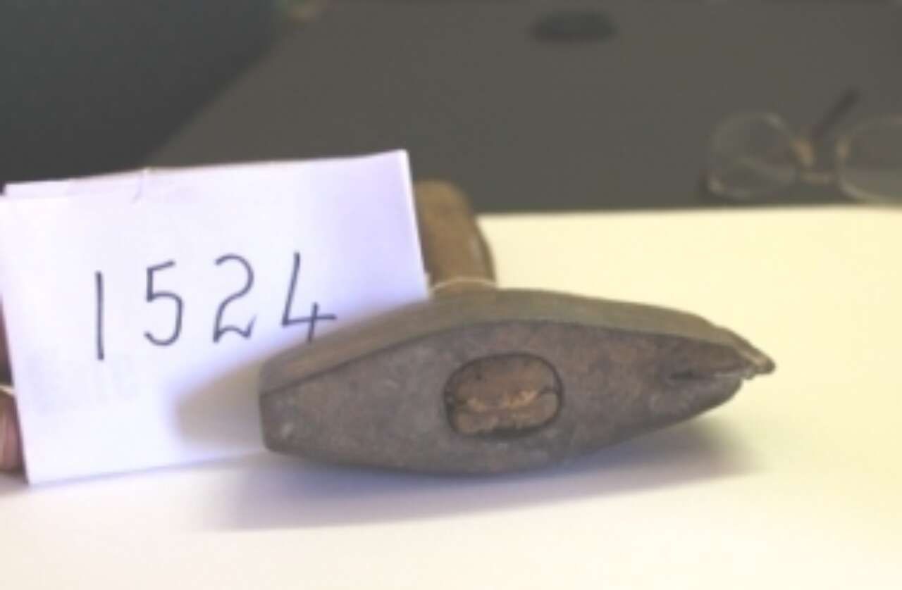 Small gray oval object with a label marked “1524” beside it on a table.
