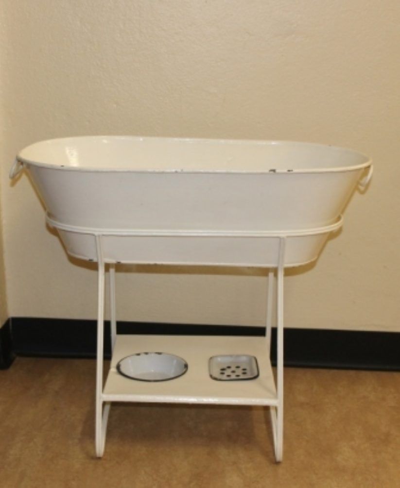 White baby changing station with attached storage shelf and two small trays against a beige wall.