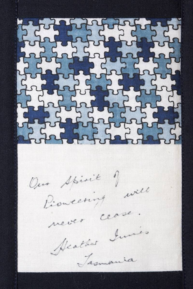 Blue and white puzzle-pattern fabric above a handwritten note on white paper
