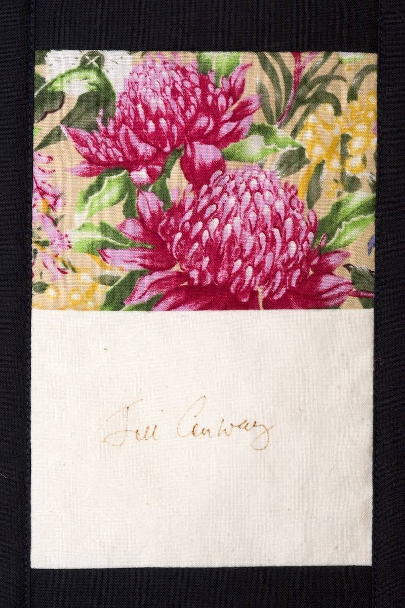 Pink flowers on patterned paper above a white card with faint handwritten text