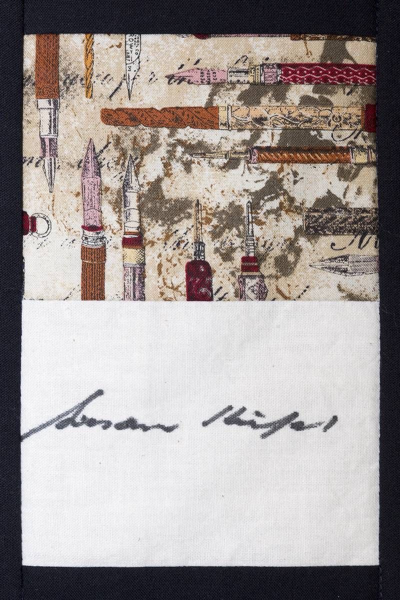 Abstract fabric pattern with a handwritten signature on white paper below