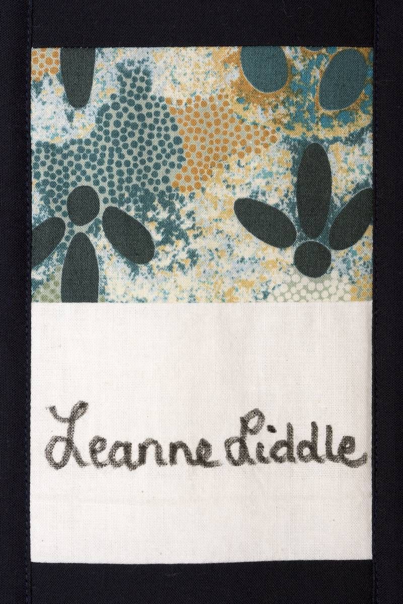 Patterned fabric label with handwritten “Leanne Ciddle” text