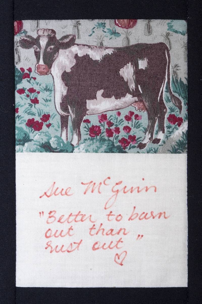 Cow in a floral patchwork block with handwritten red text below