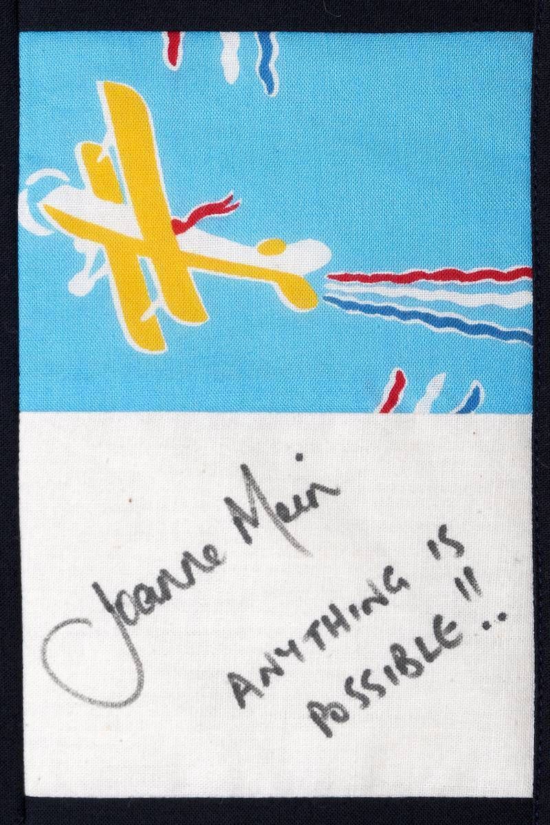 Handwritten note reading “Anything is possible!!” beneath a colorful abstract drawing on blue and white paper