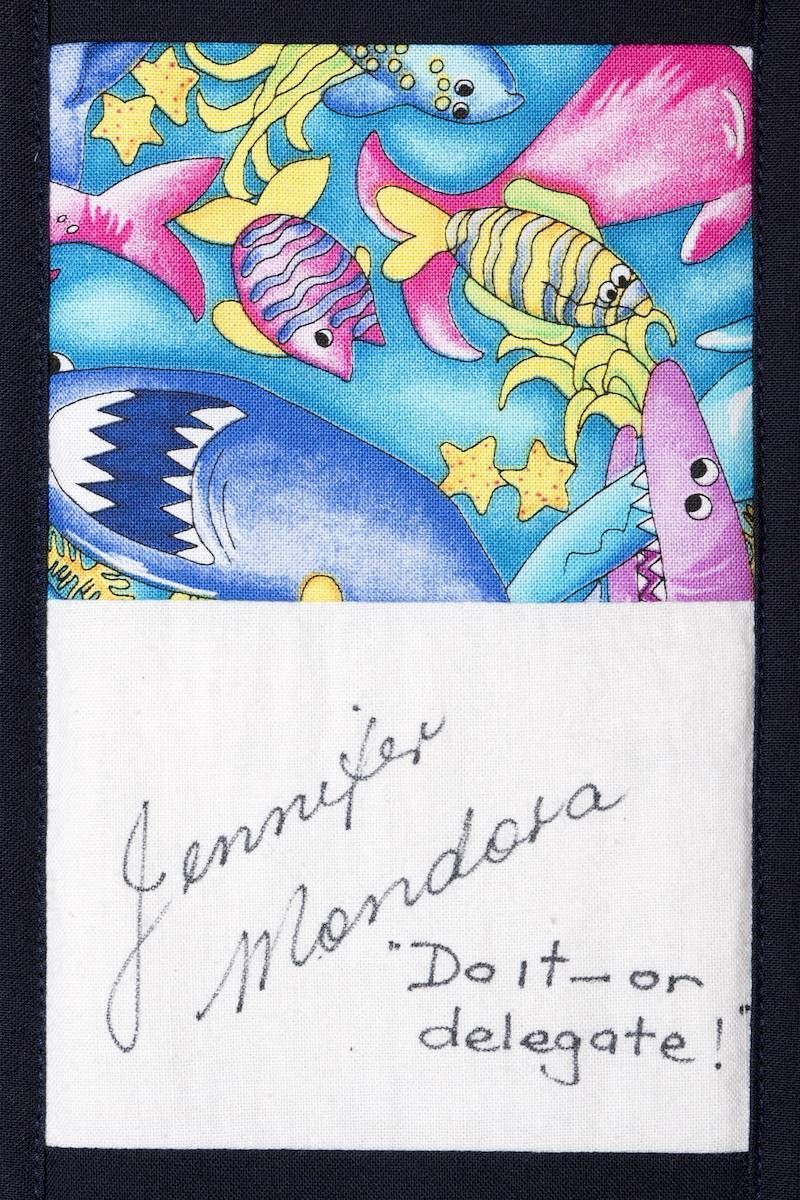Autographed notebook page with colorful fish illustrations and handwritten note “Do it on delegate!”