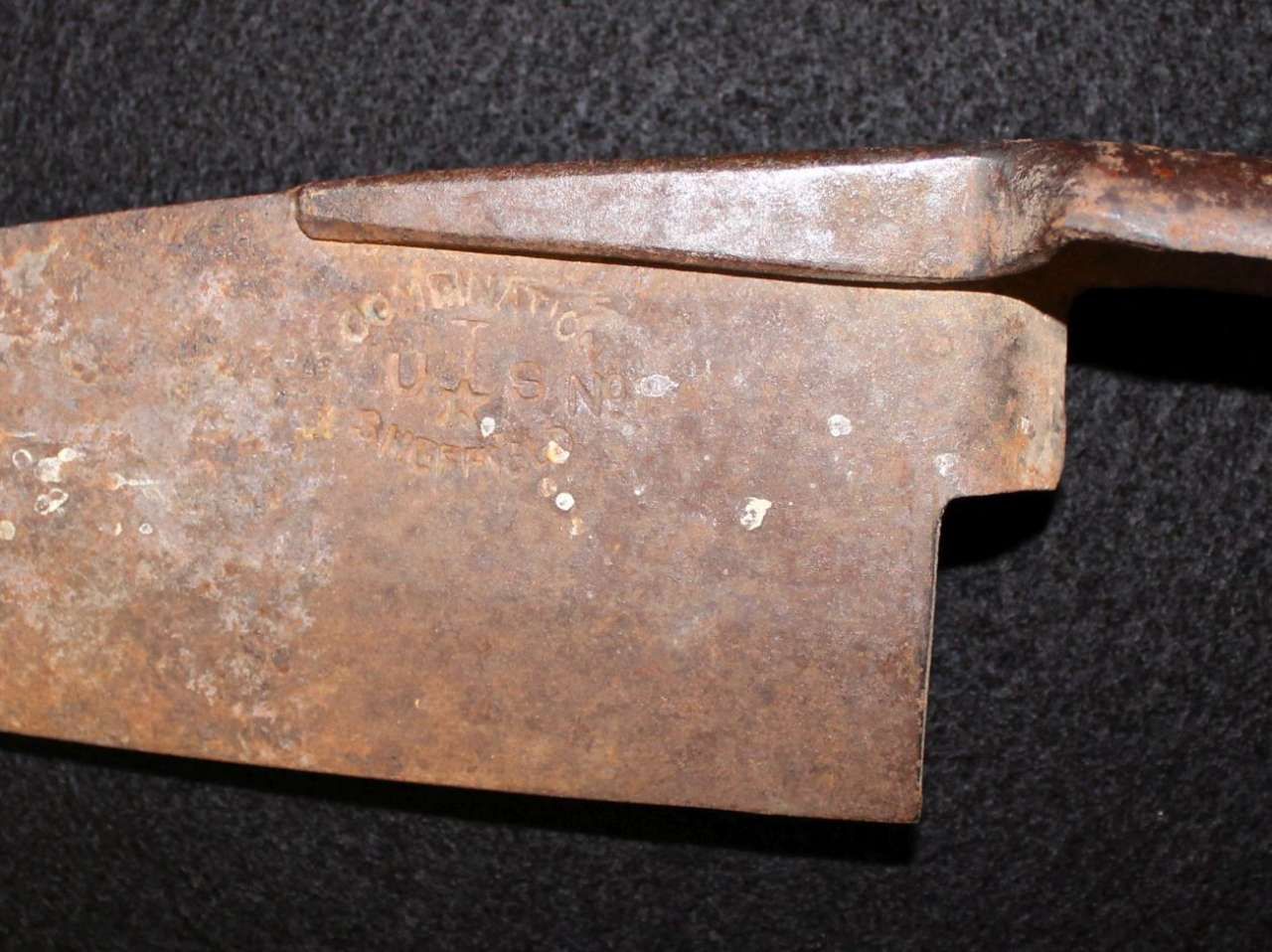 Rusty old hand tool blade on a dark surface