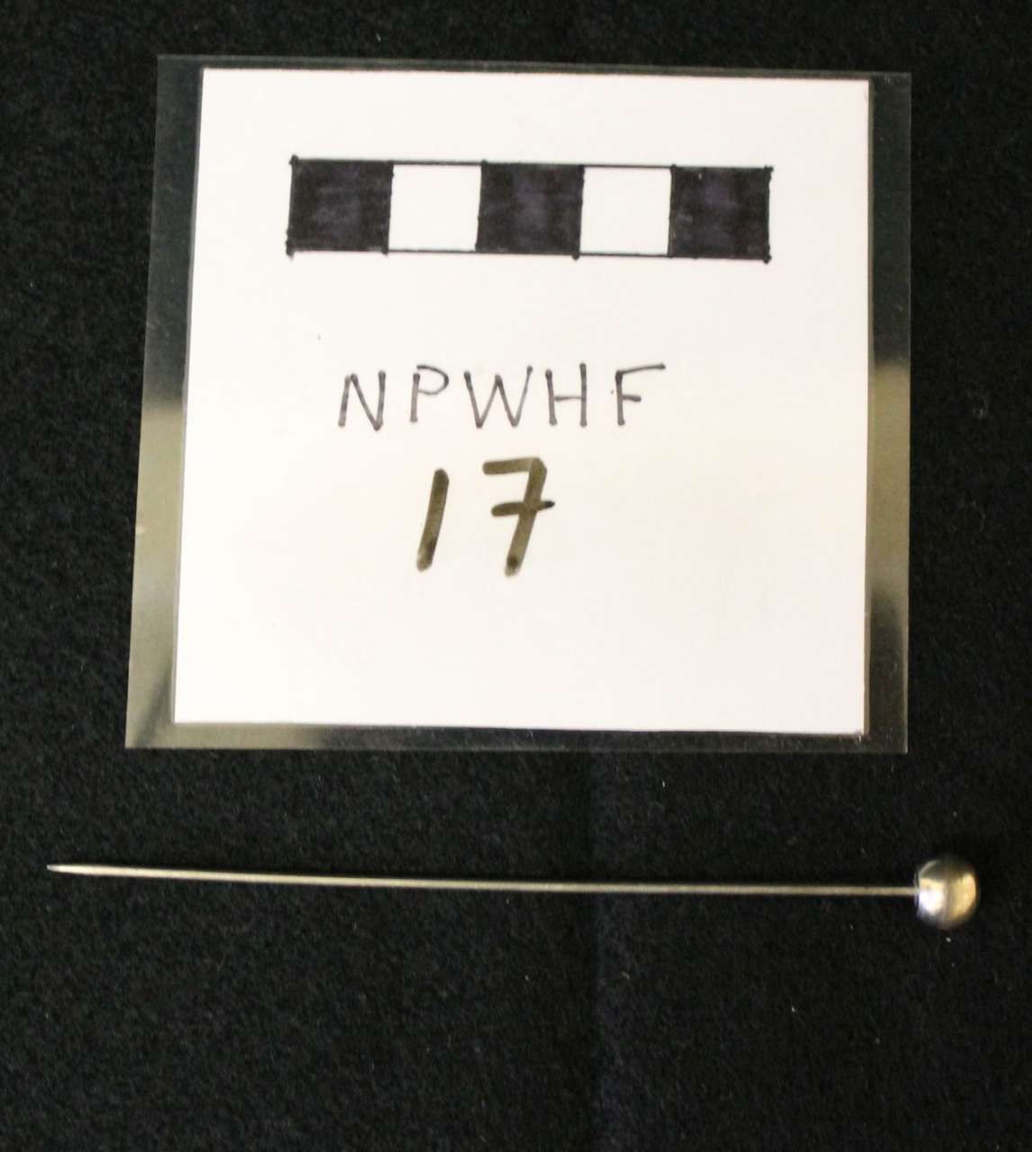 Black-and-white reference card labeled “NPWHF 17” with a small metal ball and rod below it.