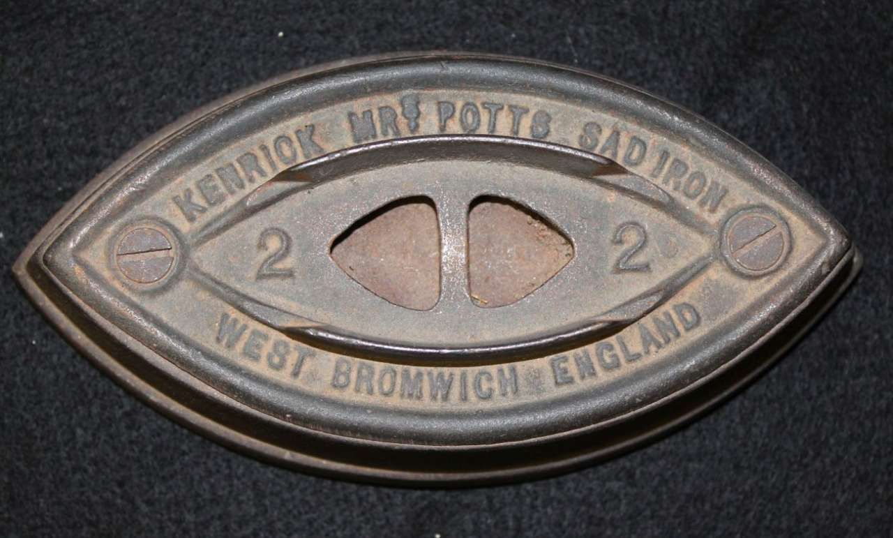Close-up of an oval brass badge with engraved text and the number 2 on a dark background