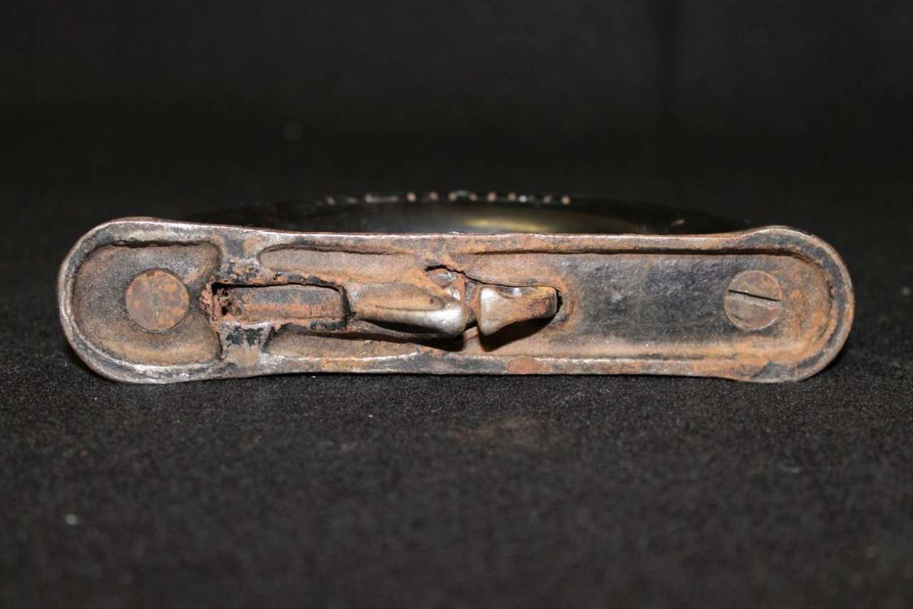 Rusty metal latch or clasp on a black background