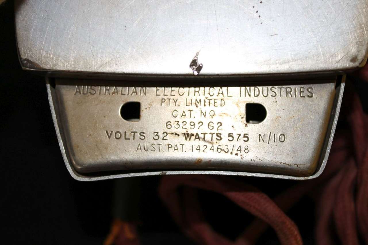 Close-up of a silver metal appliance label with engraved text and a hole cutout