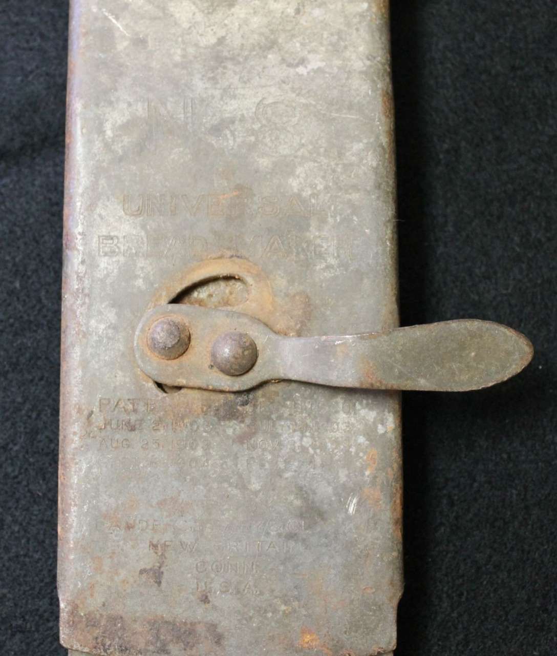 Close-up of a rusty metal latch on a weathered gray door or box.