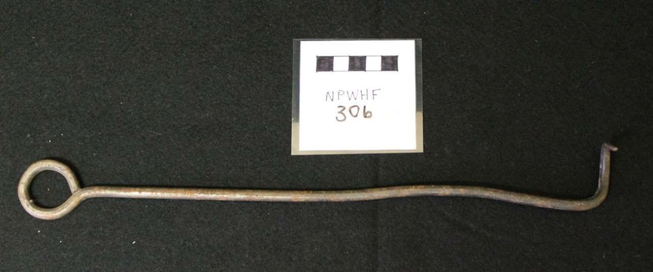 Long metal hook tool with a ring handle, shown beside a small label on a dark background.